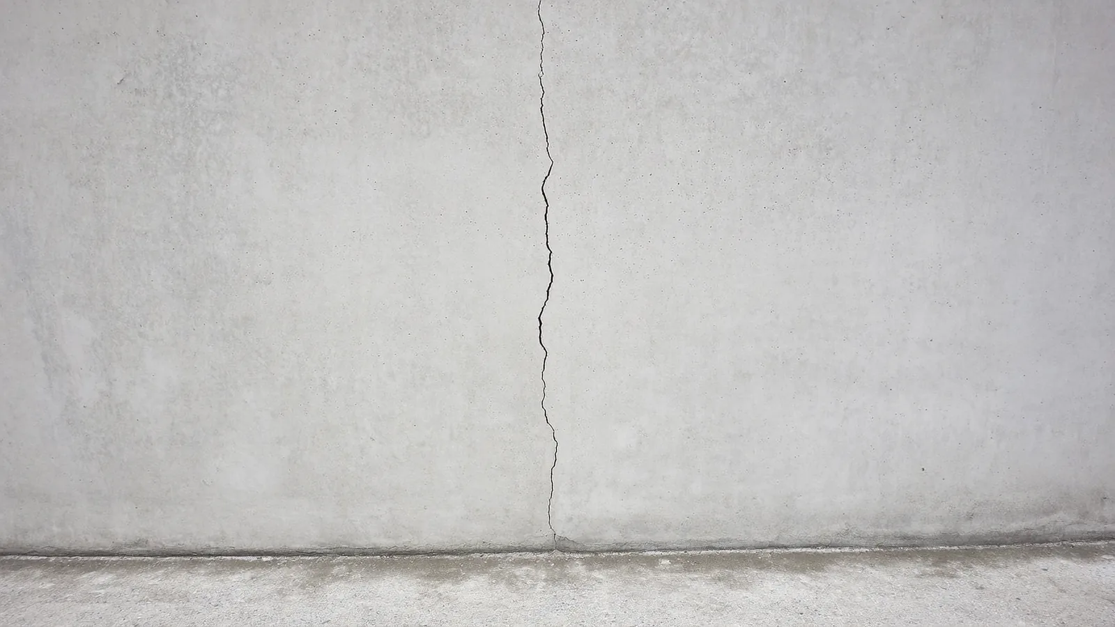 Vertical crack running down a poured concrete foundation wall in a Knoxville Tennessee home crawl space